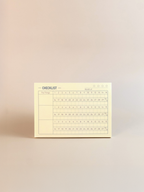 Yellow checklist pad on a beige background