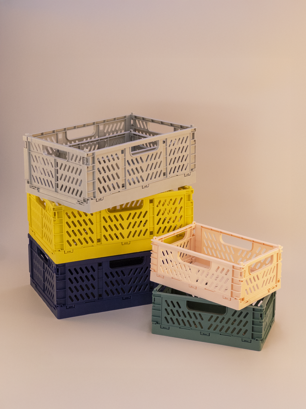 Stack of colorful plastic crates on a neutral background