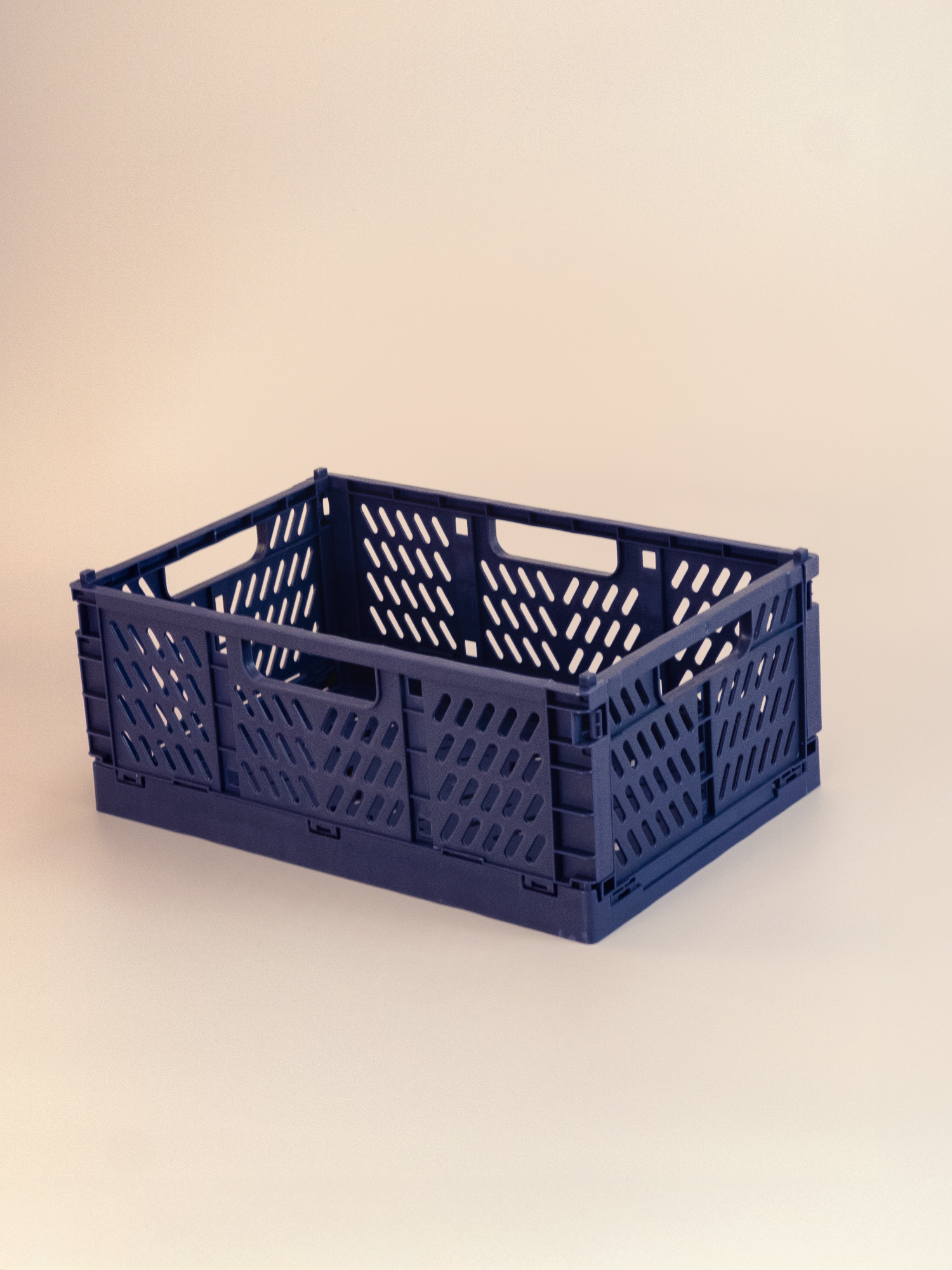 Navy blue plastic crate on a beige background
