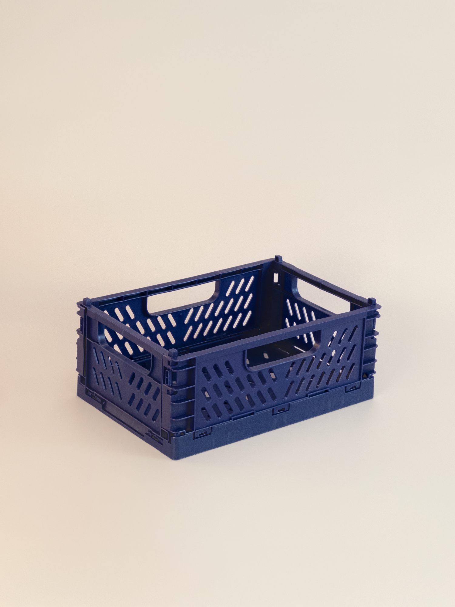 Navy blue crate with handles on a beige background