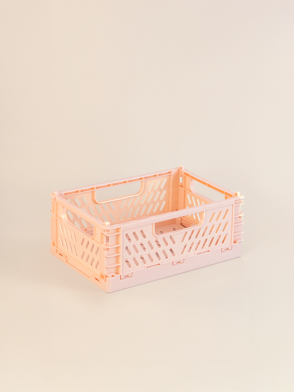 Small pink plastic crate on a beige background