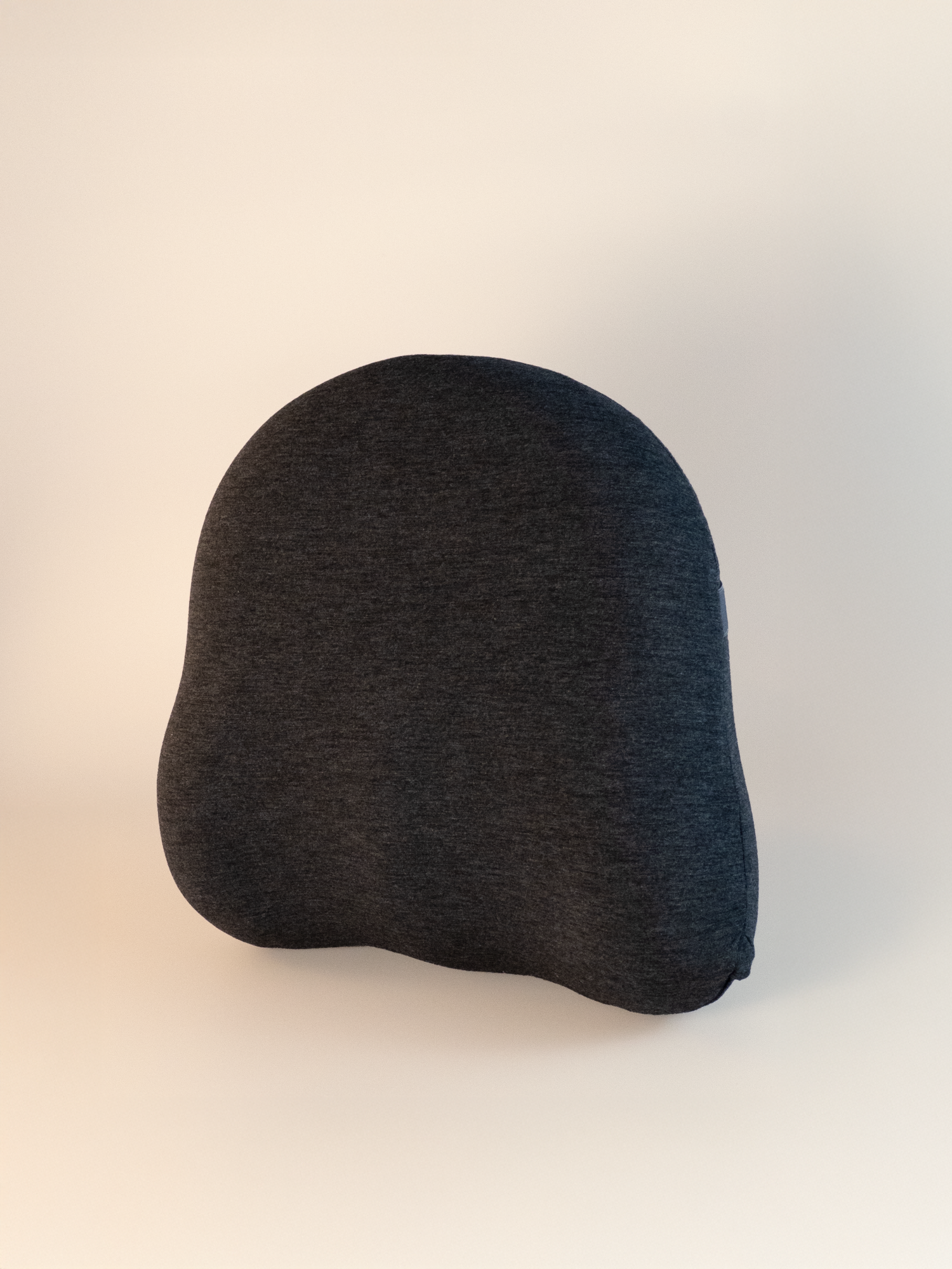 Dark gray or black waist support cushion on a light beige background