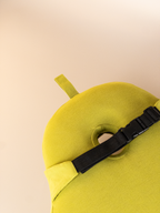 Back view of the PearRest lumbar cushion showing the black elastic strap that secures the cushion to a chair back for stable support.