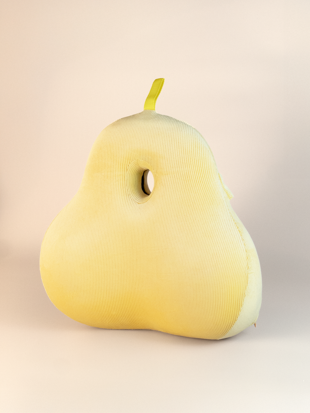 Yellow pear-shaped back support pillow on a beige background