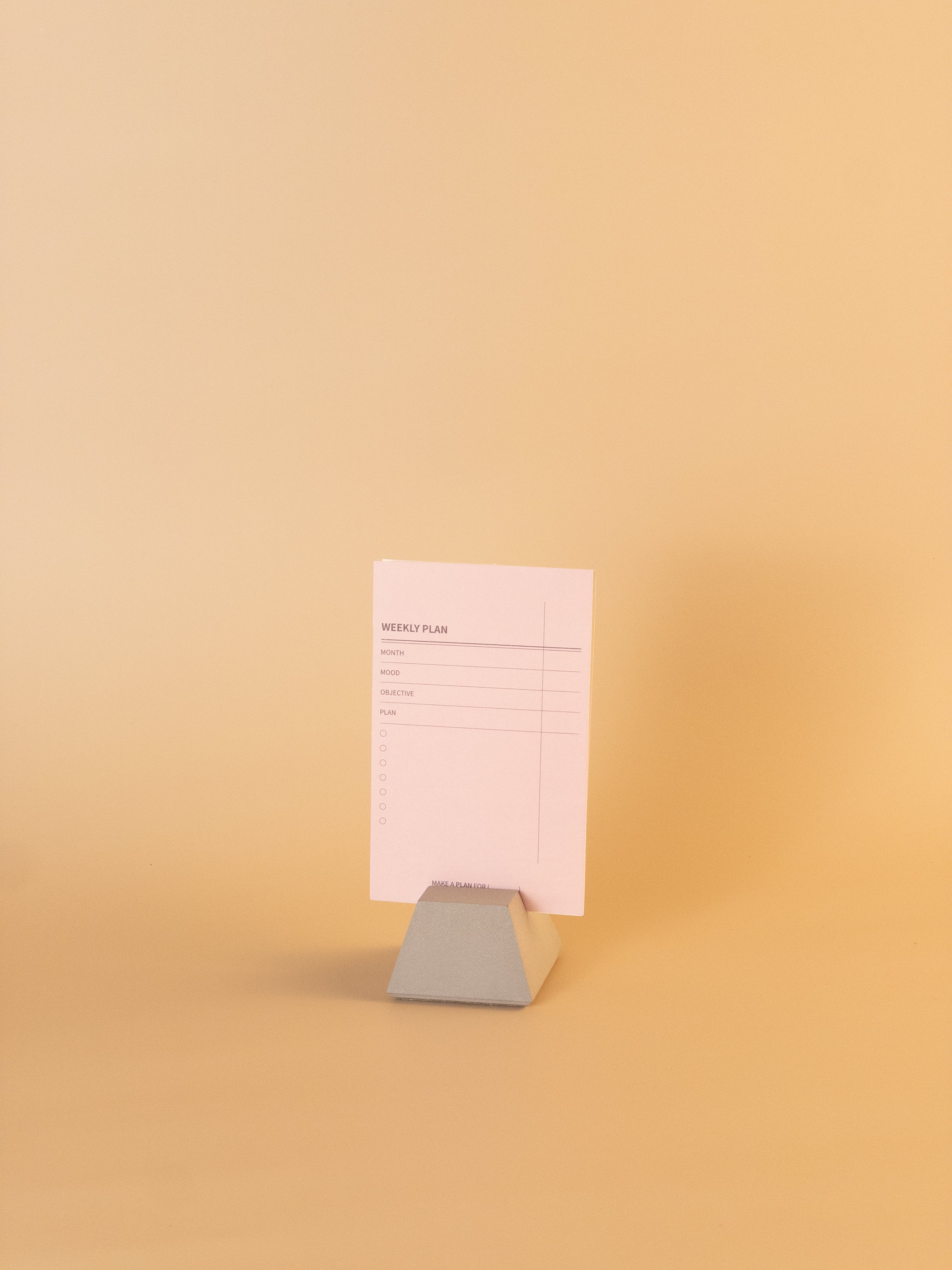 Concrete note holder displaying weekly planner card for desk organization
