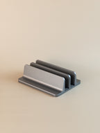 Metallic laptop vertical stand on a beige background