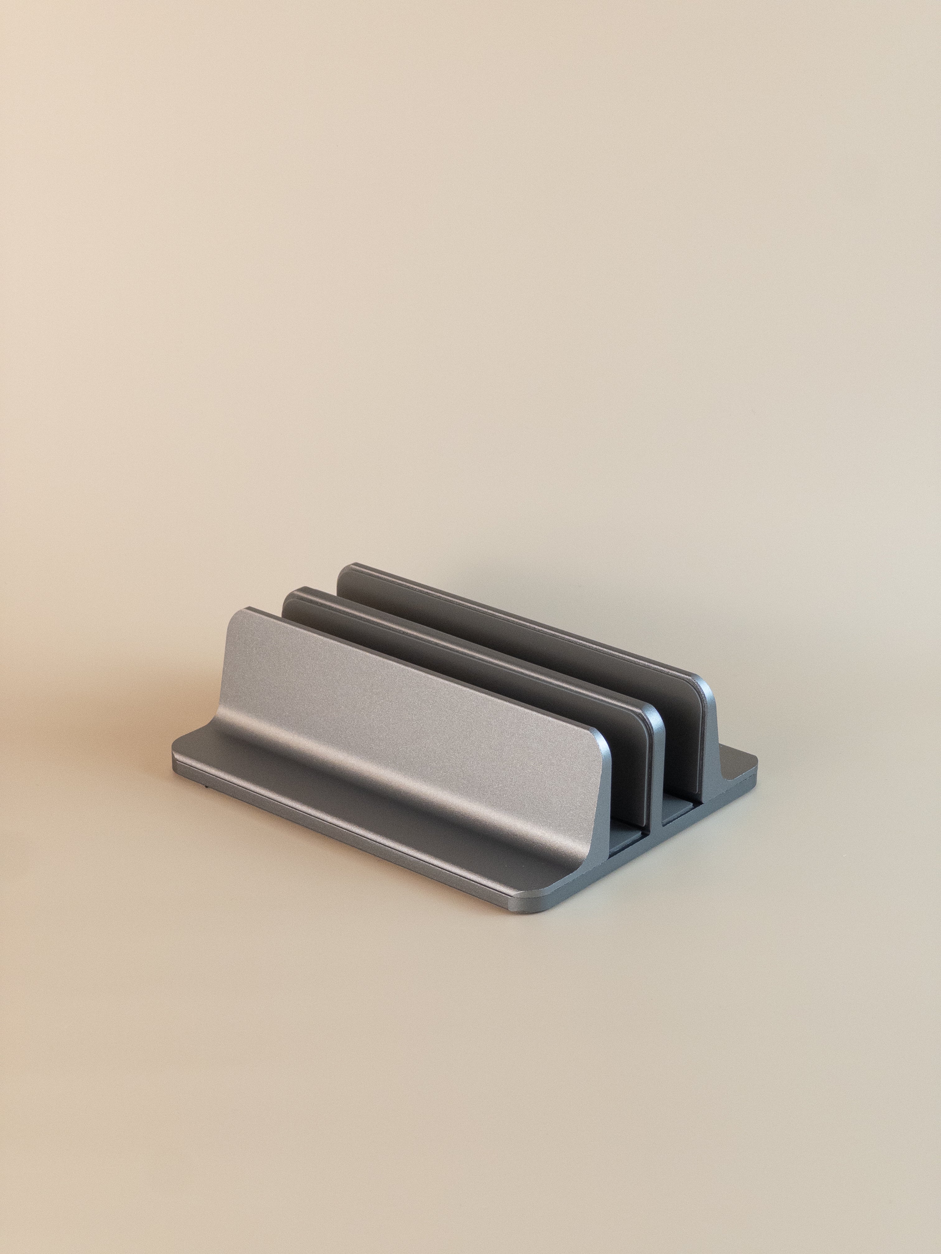 Metallic laptop vertical stand on a beige background