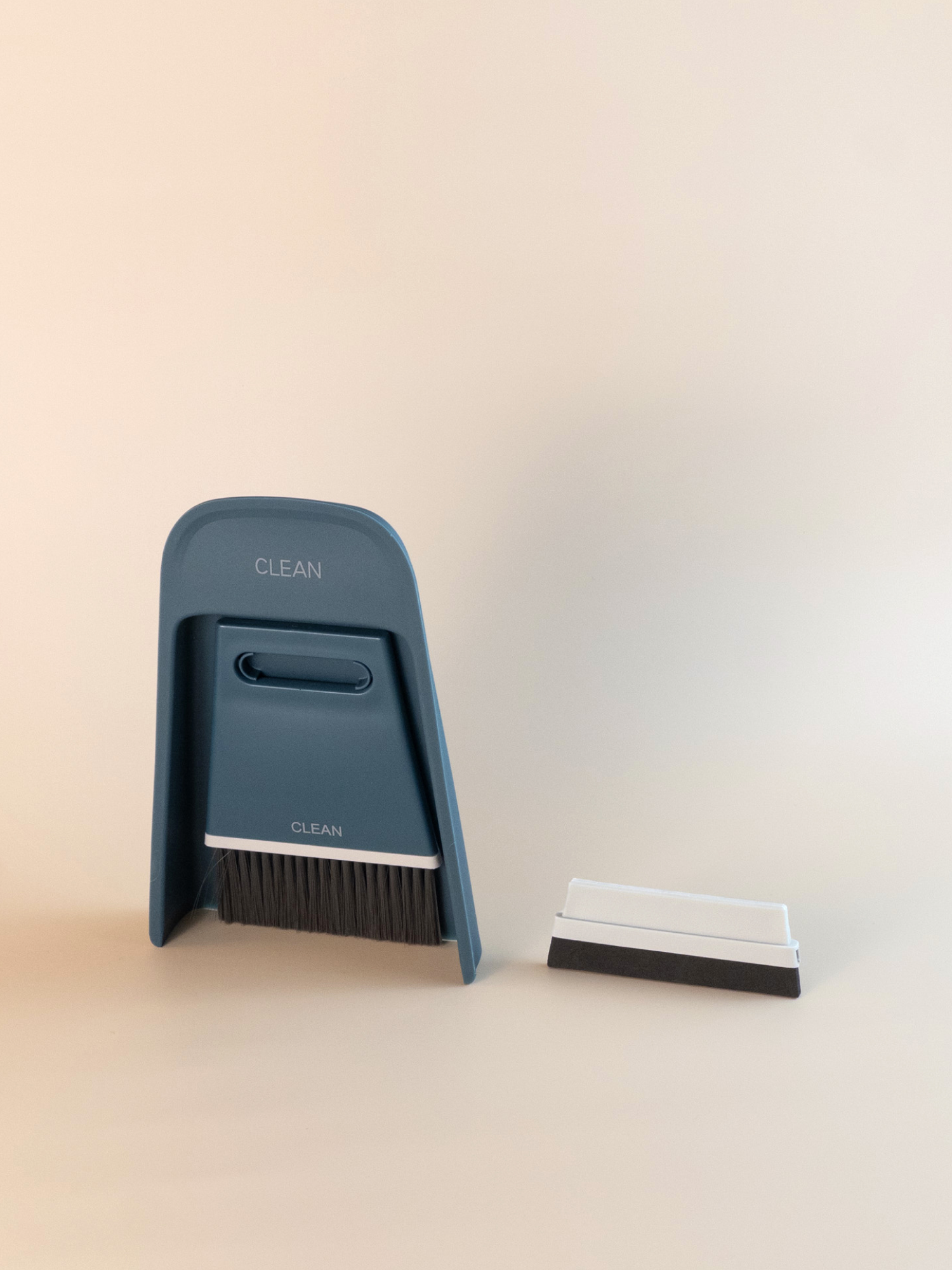 Navy blue desktop cleaning brush set, featuring soft bristles and a slim dustpan for workspace organisation.