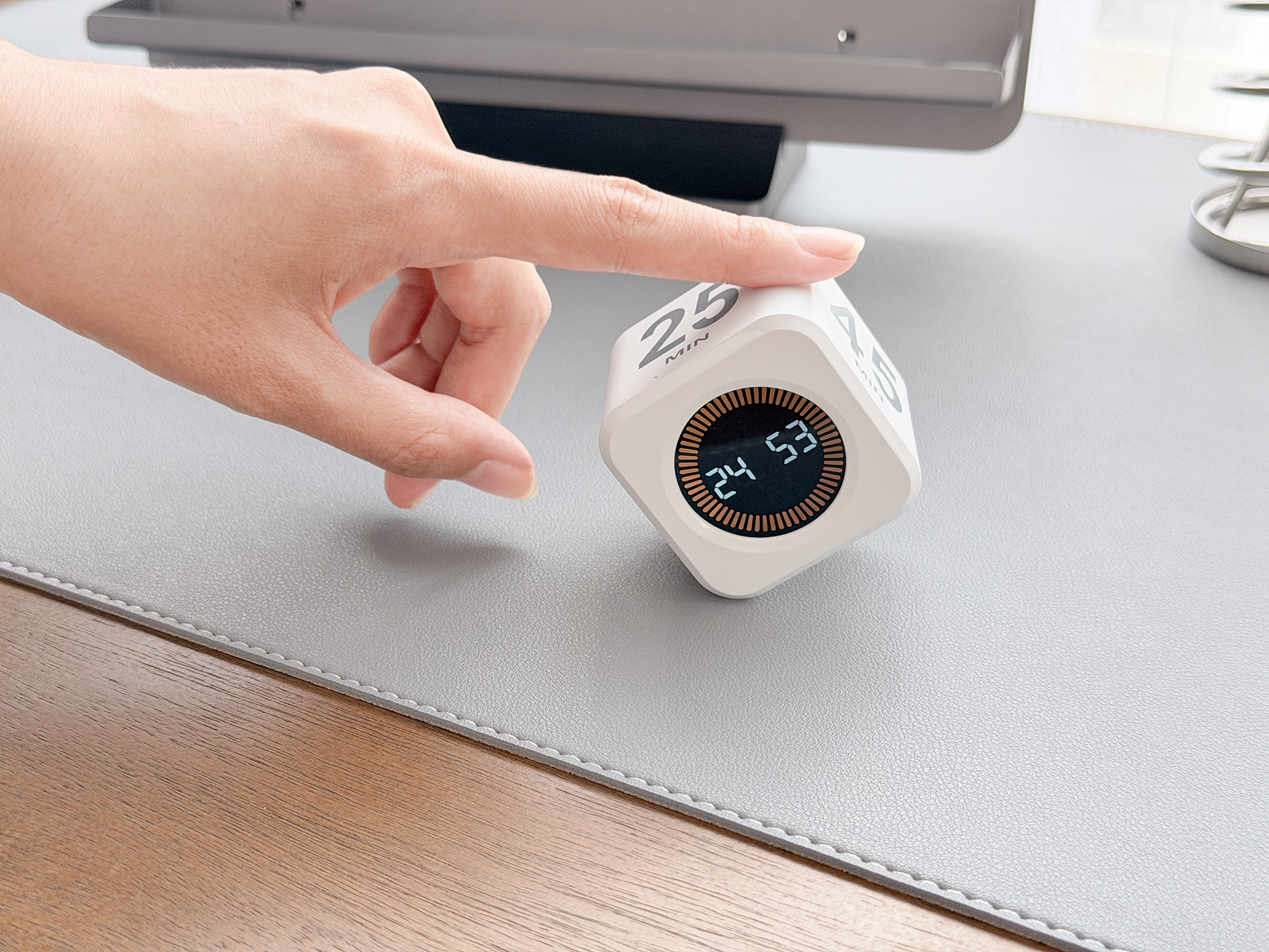Hand interacting with a digital clock on a desk