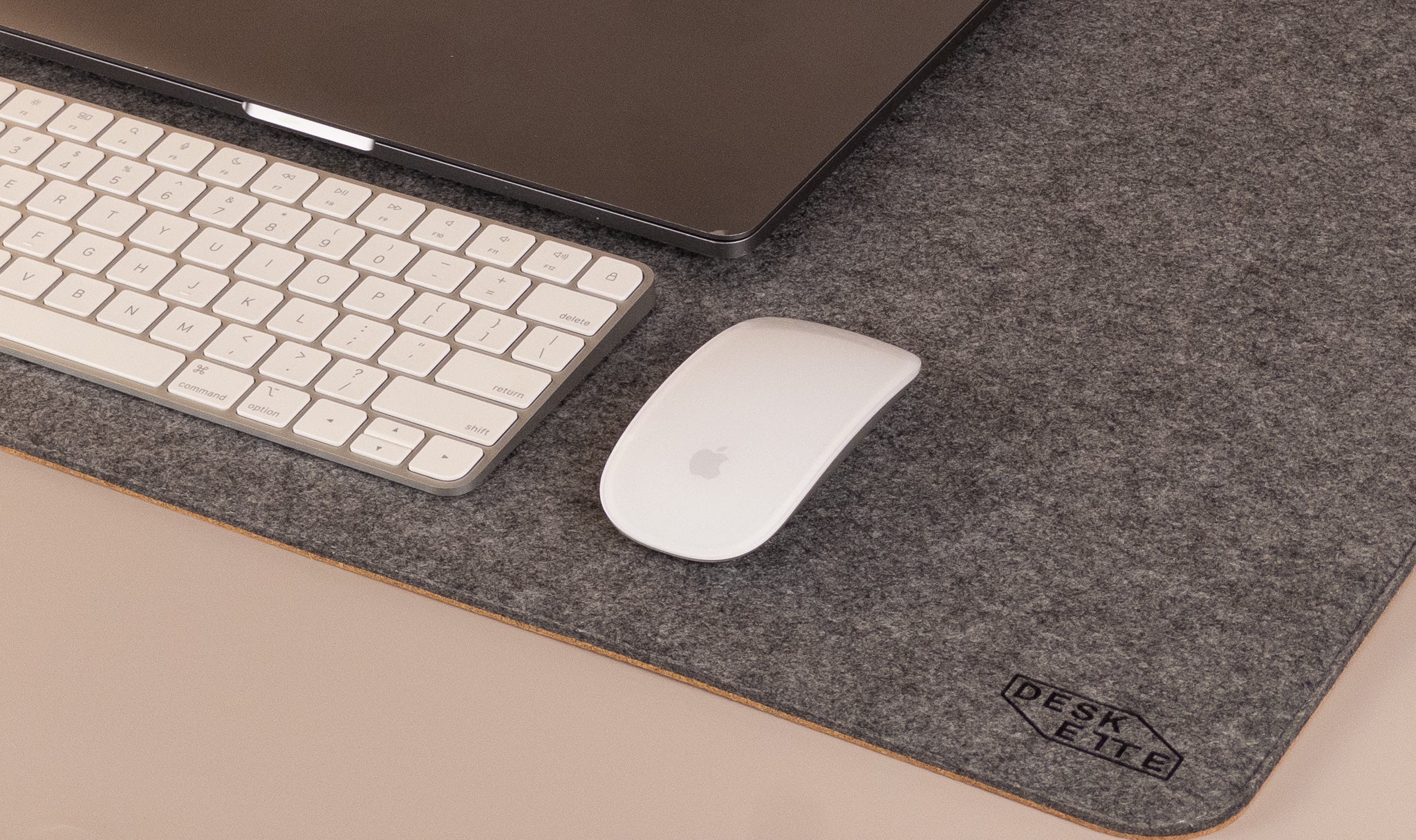 Dark grey felt and cork desk mat with laptop, keyboard, and mouse, perfect for home office setup