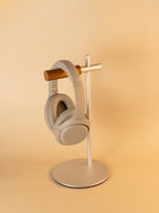 Silver aluminum headphone stand with wooden hanger holding over-ear headphones