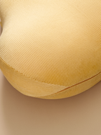 Close-up of a textured yellow cushion on a beige background