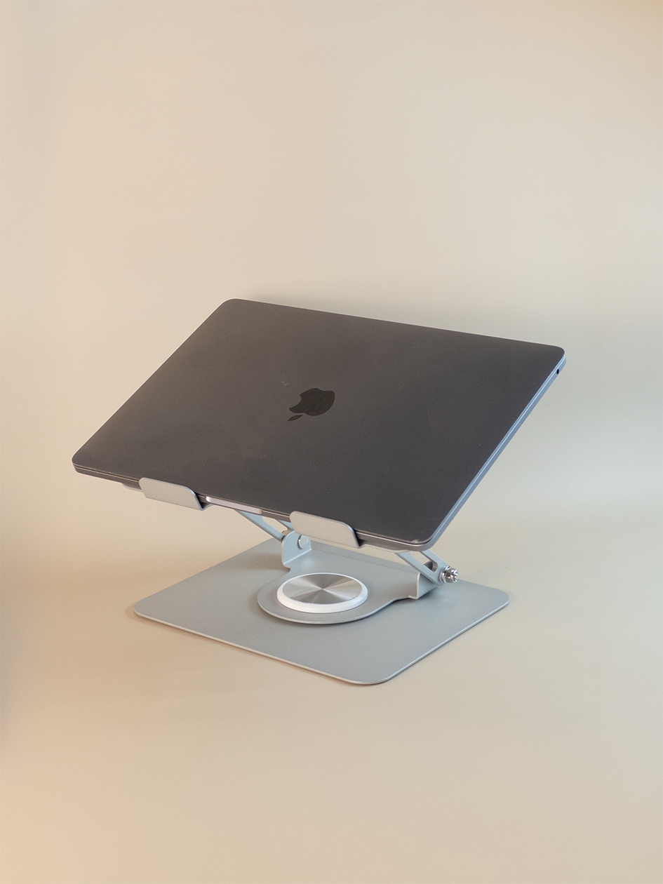 Laptop on a stand with a plain background